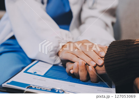 Doctor came to check the patient and shook his hand to encourage. Comforting the sick and treating the best, cured in the hospital. Doctor came to check the patient and shook his hand to encourage. Comforting the sick and treating the best, cured in the hospital. 127053069