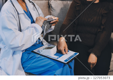 Doctor using Blood pressure monitor and stethoscope checking measuring arterial blood pressure on arm to a patient in the hospital, healthcare and medical concept Doctor using Blood pressure monitor and stethoscope checking measuring arterial blood pressure on arm to a patient in the hospital, healthcare and medical concept 127053073