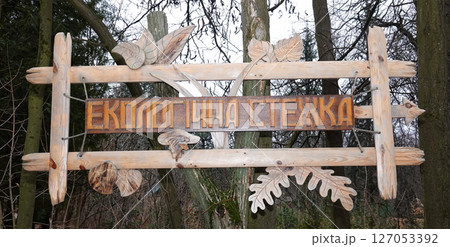 Kyiv, Ukraine January 27, 2025:  Wooden carved signpost of Eco-friendly path on the territory of the Botanical Garden of the National University of Life and Environmental Sciences of Ukraine 127053392