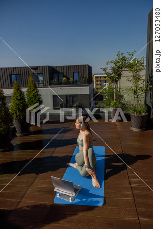 Engaging in an Outdoor Yoga Practice on a Rooftop, Enhanced with Digital Guidance and Tools Engaging in an Outdoor Yoga Practice on a Rooftop, Enhanced with Digital Guidance and Tools 127053480