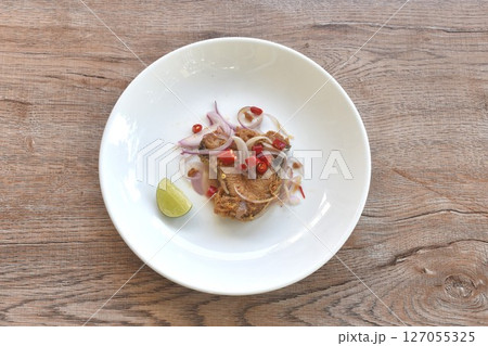 salty dry Indo-Pacific king mackerel fish topping chop shallot and chili with slice lemon salad on plate salty dry Indo-Pacific king mackerel fish topping chop shallot and chili with slice lemon salad on plate 127055325