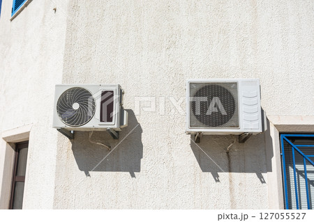 Two air conditioning units on facade. Climate control, summer infrastructure, and residential cooling in urban housing. 127055527
