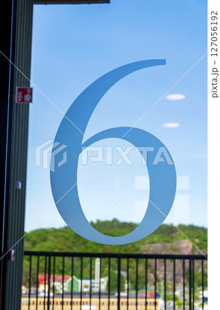 Number 6 on the glass door of an apartment building, sunny day Number 6 on the glass door of an apartment building, sunny day 127056192