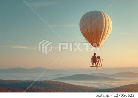 Remote Professional Working on a Desk Setup While Enjoying a Hot Air Balloon Ride in Nature 127056622