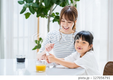 リビングでタブレットを一緒に見る親子 127056791