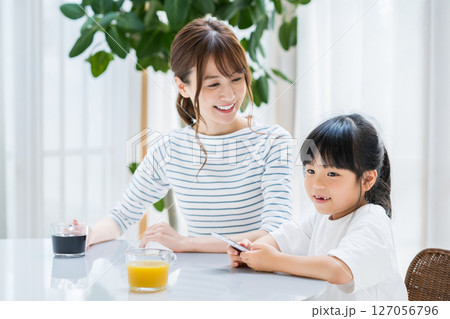 リビングでタブレットを一緒に見る親子 127056796