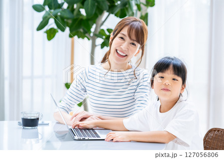 リビングでタブレットを一緒に見る親子 127056806