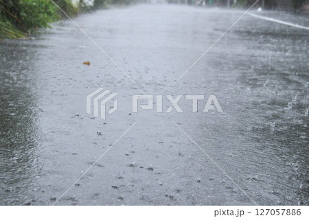 大雨で道路の水たまりに打つつける雨の水紋 127057886