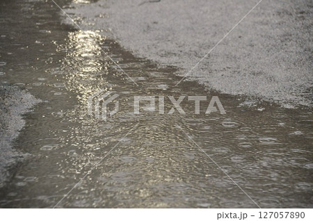 大雨で夜の道の水たまりに打つつける雨の水紋 大雨で夜の道の水たまりに打つつける雨の水紋 127057890