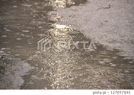 大雨で夜の道の水たまりに打つつける雨の水紋 127057891