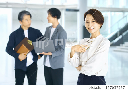 オフィスのエントランスでスマホを見るビジネスカジュアルのミドルビジネスウーマン オフィスのエントランスでスマホを見るビジネスカジュアルのミドルビジネスウーマン 127057927