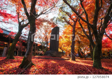 Stone statue with red fall maple leaf of Tofuku-ji temple, Kyoto Stone statue with red fall maple leaf of Tofuku-ji temple, Kyoto 127058074