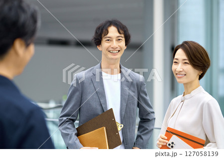 オフィスで打ち合わせする男女のビジネスチーム 127058139
