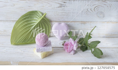 Spa still life with soap and pink rose flower on white wooden background. Spa still life with soap and pink rose flower on white wooden background. 127058575