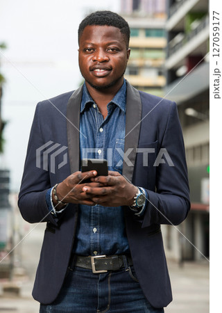 Man in business suit is enjoying modern mobile technologies. 127059177
