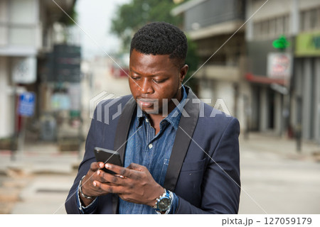 Man in business suit is enjoying modern mobile technologies. 127059179