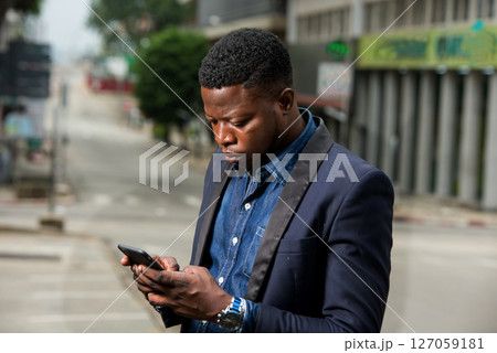 Man in business suit is enjoying modern mobile technologies. 127059181