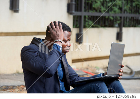 Businessman sat outside modern office block 127059268