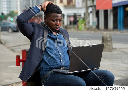 portrait of young man with laptop. 127059606