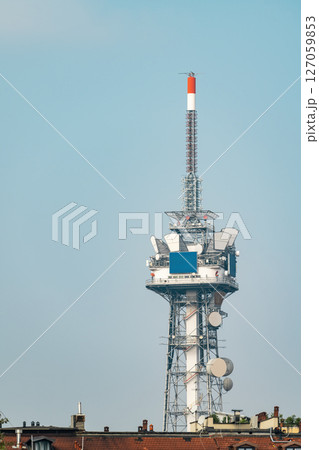 Tall communications and broadcast tower with satellite dishes on the rooftop 127059853