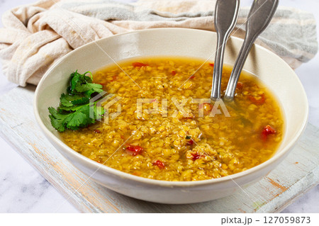 Delicious lentil soup served in a rustic bowl with herbs, perfect for a cozy meal on a chilly evening Delicious lentil soup served in a rustic bowl with herbs, perfect for a cozy meal on a chilly evening 127059873