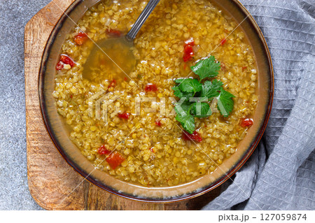 Delicious bowl of lentil soup with herbs and spices in a cozy kitchen setting Delicious bowl of lentil soup with herbs and spices in a cozy kitchen setting 127059874