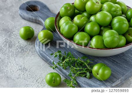 Tkemali, green cherry plum, in a bowl, on a gray table, top view, natural light, no people, 127059893