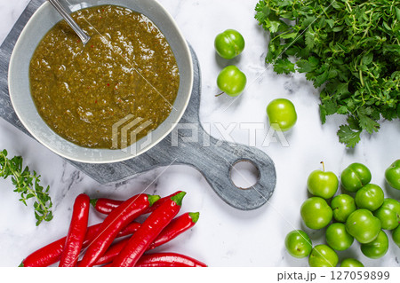 Tkemali sauce, made from green cherry plum, with ingredients on the table, top view, Georgian cuisine, no people, Tkemali sauce, made from green cherry plum, with ingredients on the table, top view, Georgian cuisine, no people, 127059899