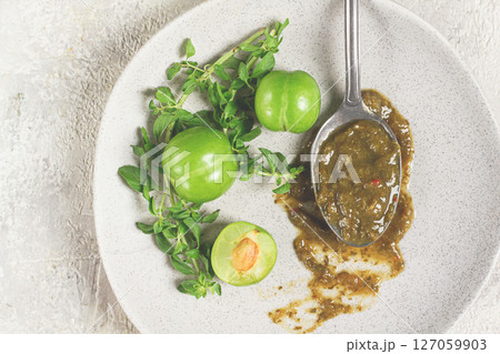 a spoon with tkemali sauce, on a plate, with cherry plum and mint, top view, no people, a spoon with tkemali sauce, on a plate, with cherry plum and mint, top view, no people, 127059903