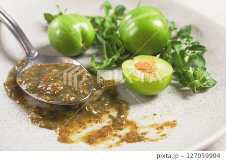 a spoon with tkemali sauce, on a plate, with cherry plum and mint, top view, no people, a spoon with tkemali sauce, on a plate, with cherry plum and mint, top view, no people, 127059904