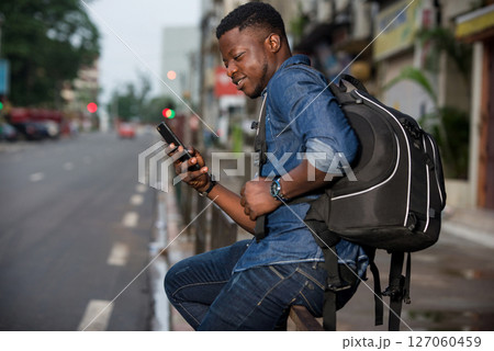 portrait of young african man with mobile phone, smiling. portrait of young african man with mobile phone, smiling. 127060459