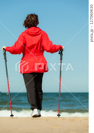 Nordic walking. Woman hiking on the beach. Nordic walking. Woman hiking on the beach. 127060630
