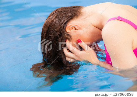 Woman having fun in swimming pool 127060859
