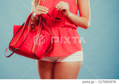 Closeup of fashion woman with red handbag. 127060876