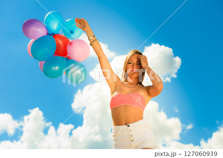 Girl holding balloons sky background 127060939