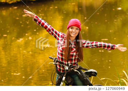 girl relaxing in autumnal park with bicycle. 127060949