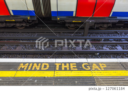 Iconic MIND THE GAP Sign on London Tube Platform, Safety Message and Train 127061184