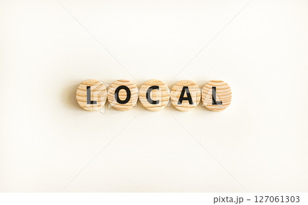 Local symbol. Concept word Local on beautiful wooden circles. Beautiful white table white background. Business lifestyle local concept. Copy space. Local symbol. Concept word Local on beautiful wooden circles. Beautiful white table white background. Business lifestyle local concept. Copy space. 127061303
