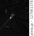 Detail of a black sweatshirt with a hood on a zipper with drawstrings and metal fittings background 127061378