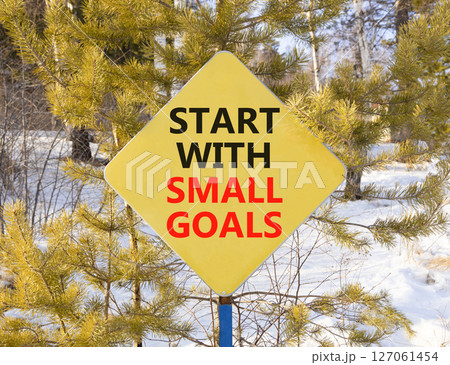 Start with small goals symbol. Concept words phrase Start with small goals on beautiful yellow road sign. Beautiful winter forest background. Business Start with small goals concept. Copy space. 127061454