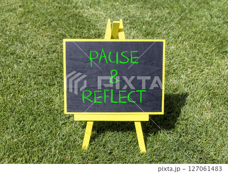 Pause and reflect symbol. Concept words Pause and reflect on beautiful yellow blackboard. Beautiful green grass lawn background. Business motivational lifestyle pause and reflect concept. Copy space. 127061483