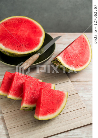 Slices of fresh watermelon on bright rustic wooden table Slices of fresh watermelon on bright rustic wooden table 127062367