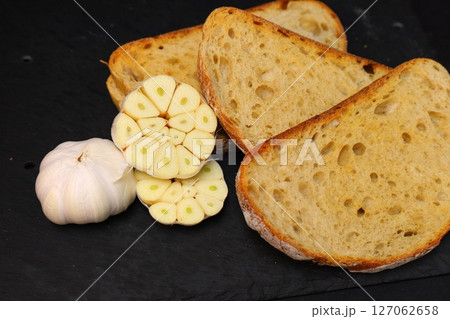 garlic and toasted bread slices on black background 127062658