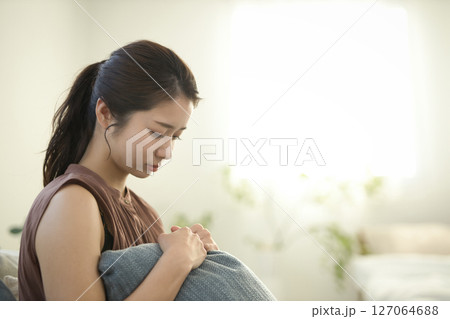 ソファに座る体調不良の20代女性 ソファに座る体調不良の20代女性 127064688