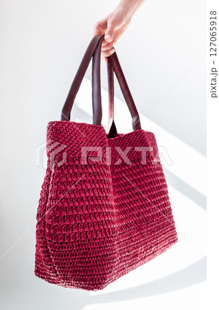 Female hand holding fashionable red woven bag. Fashion and luxury accessories. Vertical photo. High quality photo Female hand holding fashionable red woven bag. Fashion and luxury accessories. Vertical photo. High quality photo 127065918