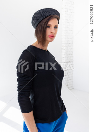 Elegant woman in black windbreaker jacket, blue pants and nautical hat on white background. Fashionable female in ocean French style. Studio photography. Vertical photo. High quality photo Elegant woman in black windbreaker jacket, blue pants and nautical hat on white background. Fashionable female in ocean French style. Studio photography. Vertical photo. High quality photo 127065921