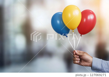 Vibrant Hand Holding Retro Colored Balloons with Vintage Instagram Filter Effect 127069271