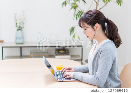 リビングでテレワークをする女性。 リビングでテレワークをする女性。 127069416