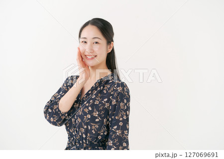 頬に手を当てる笑顔の若い女性 頬に手を当てる笑顔の若い女性 127069691