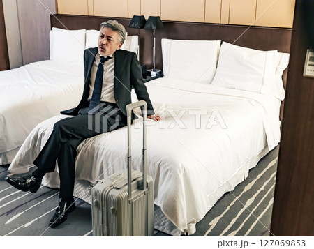 ベッドでリラックスするミドル男性ビジネスパーソン ベッドでリラックスするミドル男性ビジネスパーソン 127069853
